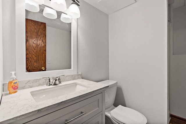 bathroom with vanity, a notable chandelier, and toilet