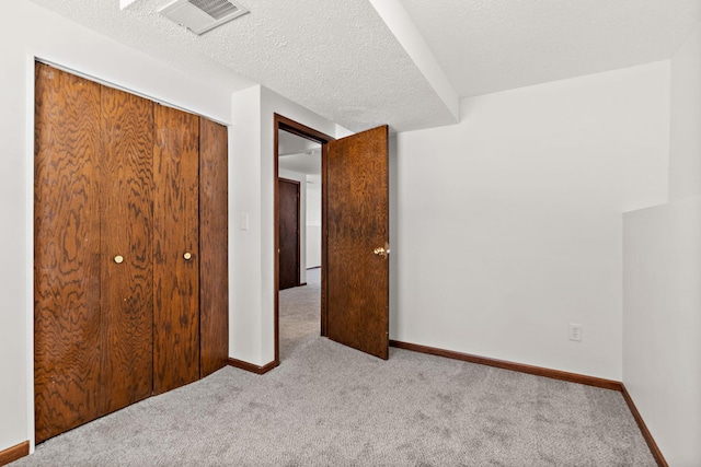 unfurnished bedroom featuring carpet flooring, visible vents, a closet, and baseboards