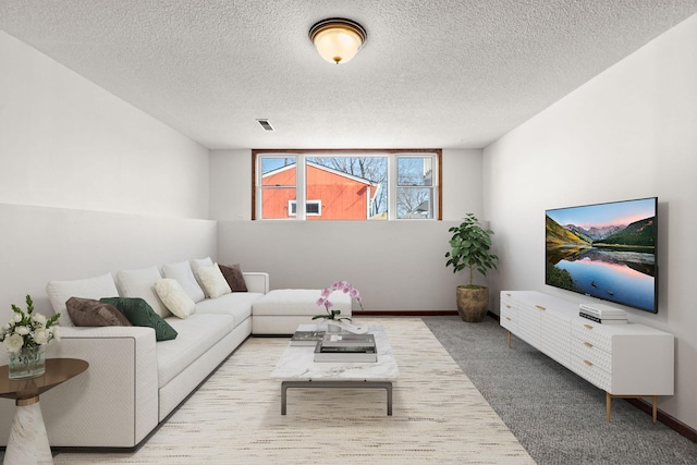 carpeted living room with visible vents, a textured ceiling, and baseboards