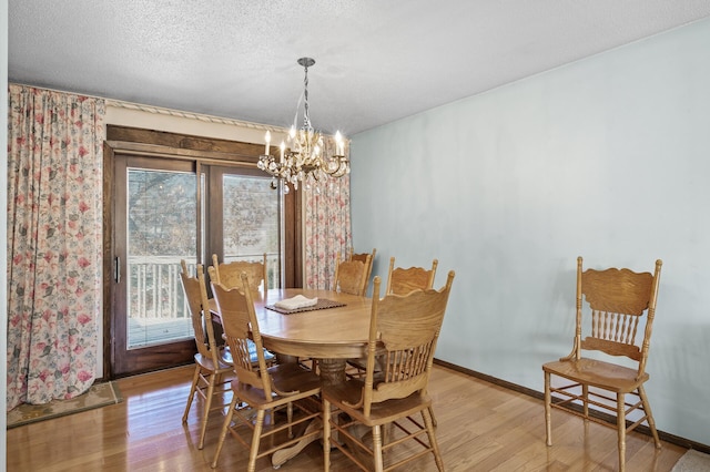 dining area with a notable chandelier, plenty of natural light, and light wood finished floors