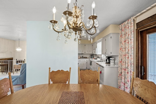 dining space with a notable chandelier and a textured ceiling