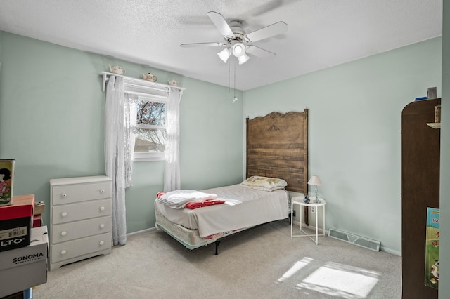 carpeted bedroom featuring visible vents, ceiling fan, a textured ceiling, and baseboards