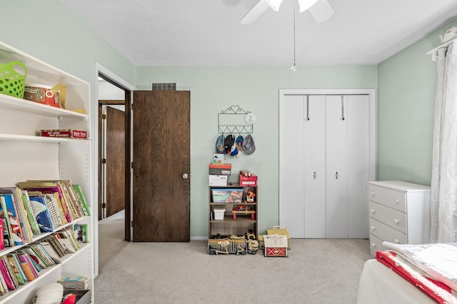 carpeted bedroom with ceiling fan, a closet, and visible vents