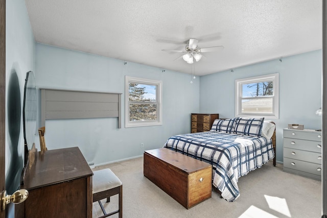 carpeted bedroom with multiple windows, ceiling fan, a textured ceiling, and baseboards