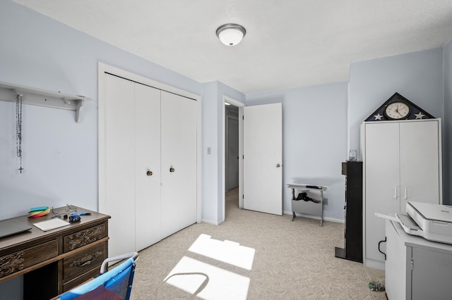 bedroom featuring a closet, light colored carpet, and baseboards