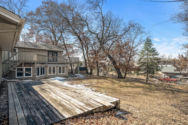 view of yard featuring driveway, a wooden deck, and stairs