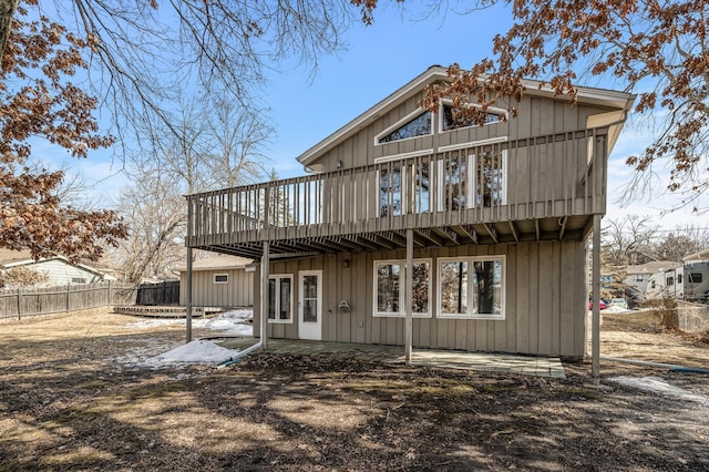 back of house with a wooden deck, fence, and a patio