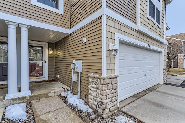 doorway to property featuring stone siding and an attached garage