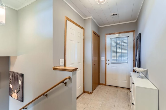 entryway featuring light tile patterned floors, visible vents, and crown molding