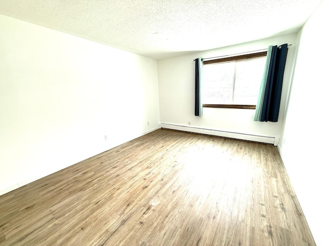 unfurnished room featuring a baseboard radiator, a textured ceiling, and wood finished floors