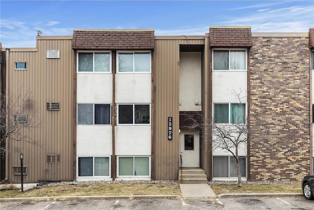 view of property featuring uncovered parking and entry steps