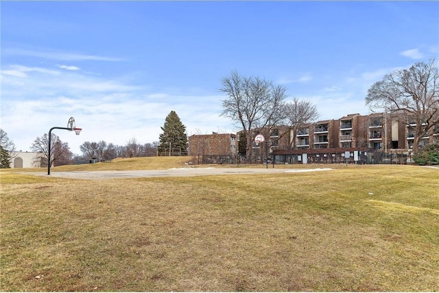 surrounding community featuring community basketball court and a lawn