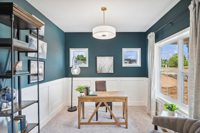 carpeted home office featuring a wainscoted wall