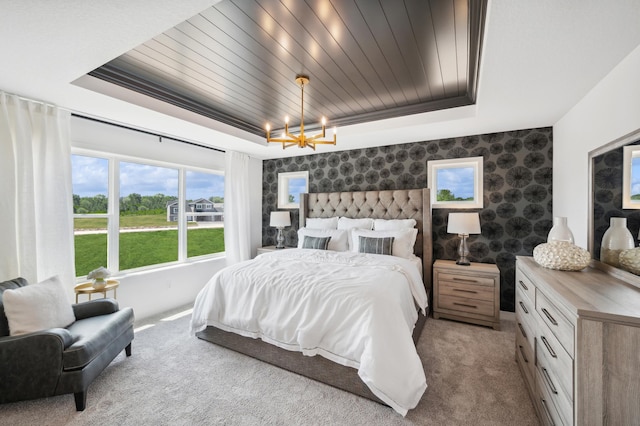 carpeted bedroom with a tray ceiling, wooden ceiling, and wallpapered walls