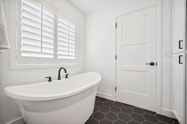 bathroom with a freestanding tub and baseboards