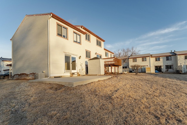 rear view of property with cooling unit and a patio