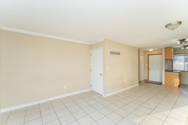 empty room featuring visible vents, baseboards, and ornamental molding