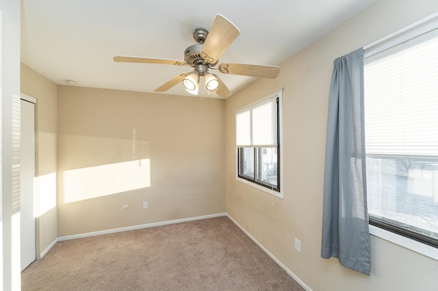 unfurnished room featuring carpet flooring, a ceiling fan, and baseboards