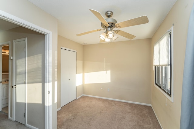 unfurnished bedroom with carpet flooring, baseboards, a closet, and ceiling fan