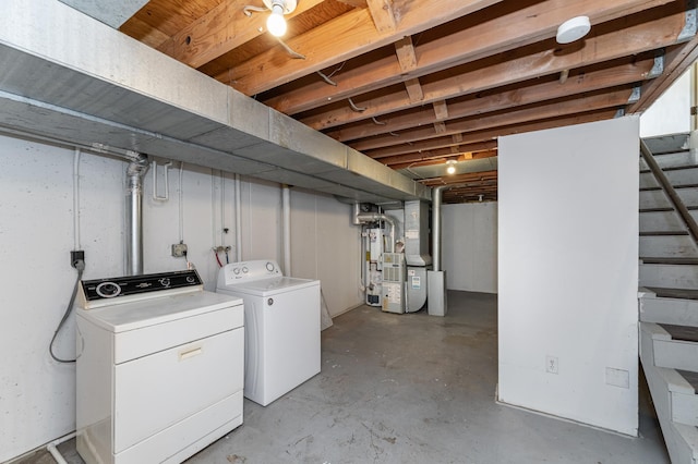 unfinished basement with stairway, heating unit, and washer and clothes dryer