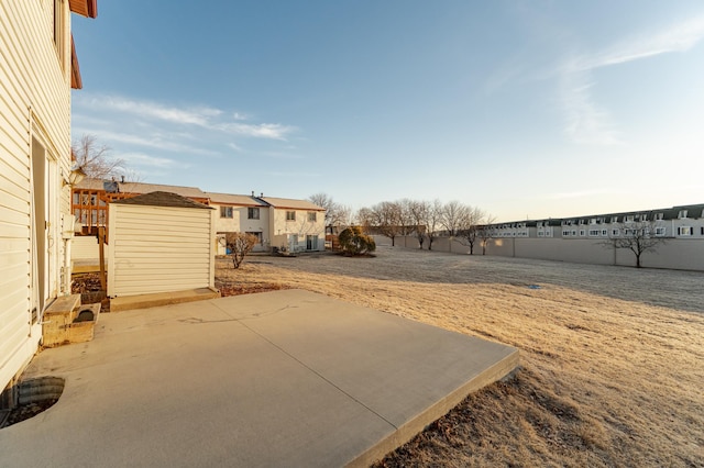 view of yard featuring a storage unit, an outdoor structure, and a patio area