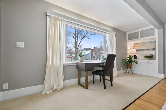 home office featuring carpet flooring, wood finished floors, and baseboards