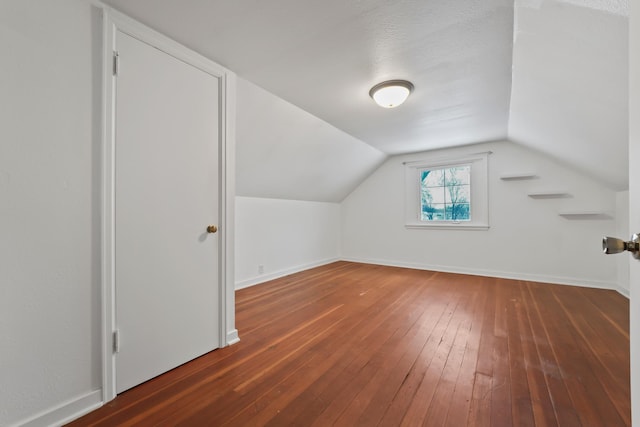 additional living space with vaulted ceiling, baseboards, and hardwood / wood-style flooring