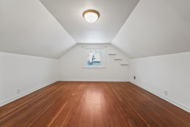 bonus room featuring baseboards, lofted ceiling, and hardwood / wood-style floors