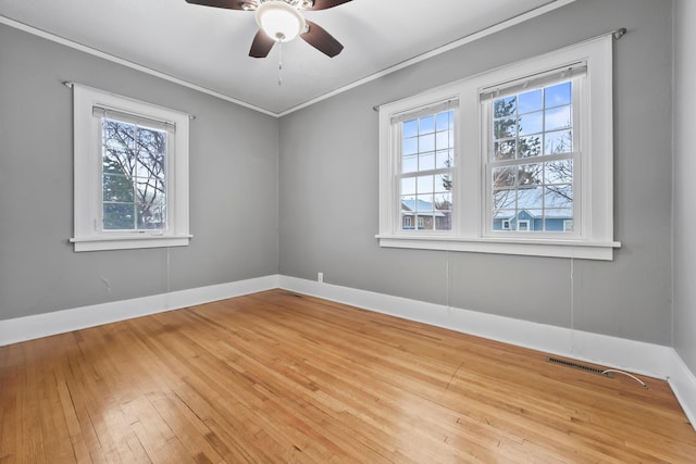 unfurnished room featuring visible vents, hardwood / wood-style floors, baseboards, and ornamental molding