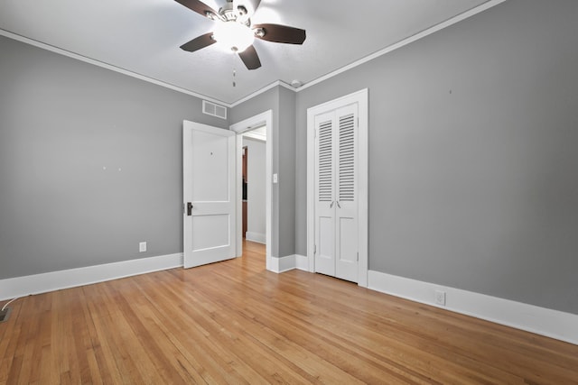 unfurnished bedroom with visible vents, crown molding, light wood finished floors, baseboards, and ceiling fan