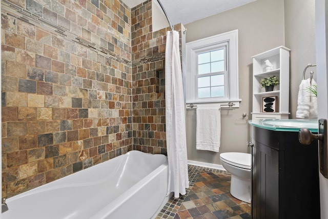 bathroom with toilet, vanity, and baseboards