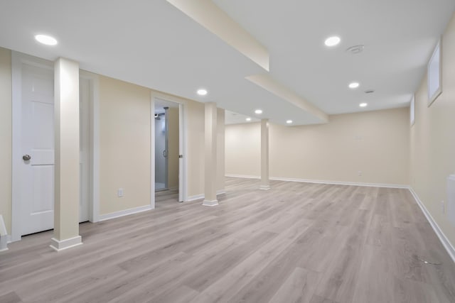 finished basement with recessed lighting, baseboards, and light wood-style floors