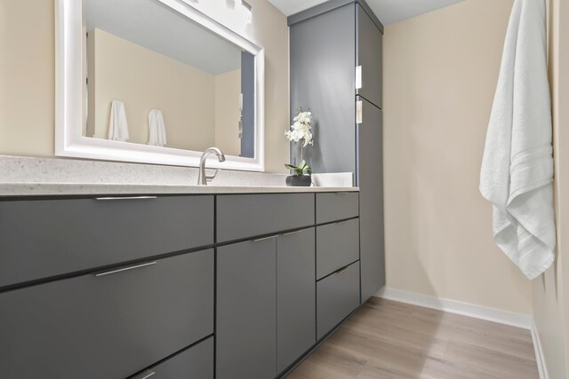 bathroom with vanity, baseboards, and wood finished floors