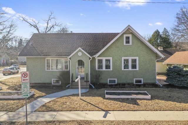 view of front of home with roof with shingles and stucco siding