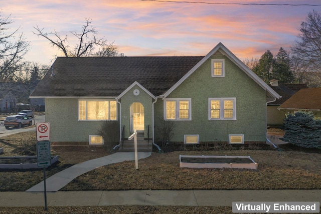 view of front of property with stucco siding and roof with shingles