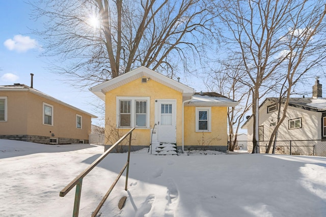 view of front of home featuring entry steps, fence, and stucco siding