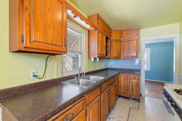 kitchen featuring a sink, dark countertops, and brown cabinetry