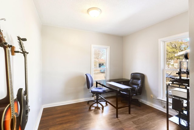 office space featuring dark wood-type flooring, a healthy amount of sunlight, and baseboards