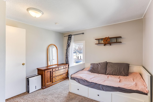 bedroom with light colored carpet and a textured ceiling