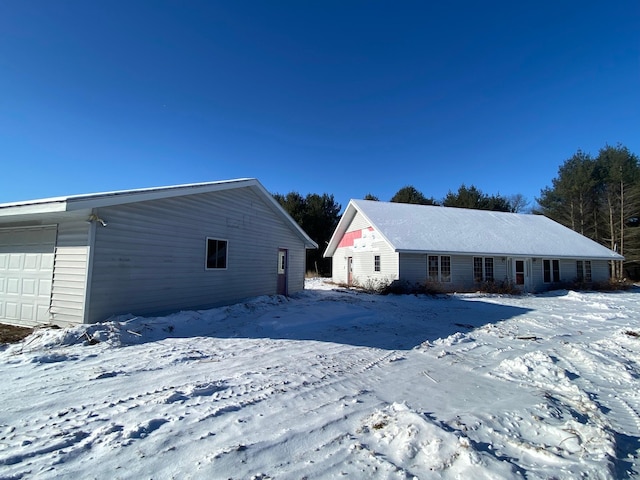 snow covered property featuring a garage