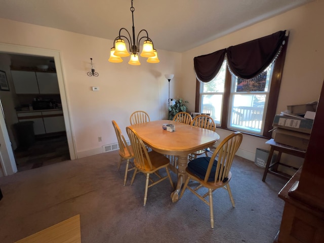 carpeted dining room featuring visible vents, a notable chandelier, and baseboards