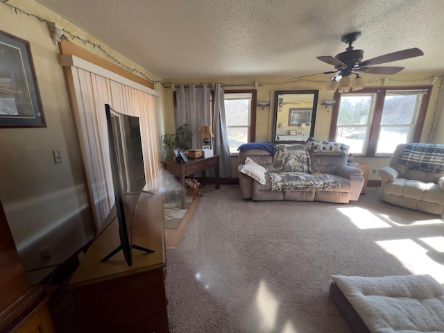 carpeted living room featuring a ceiling fan and a textured ceiling