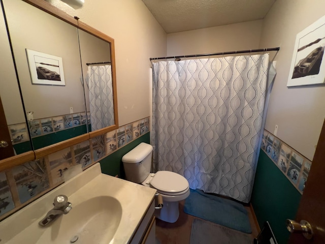 bathroom featuring a shower with shower curtain, toilet, vanity, and a textured ceiling