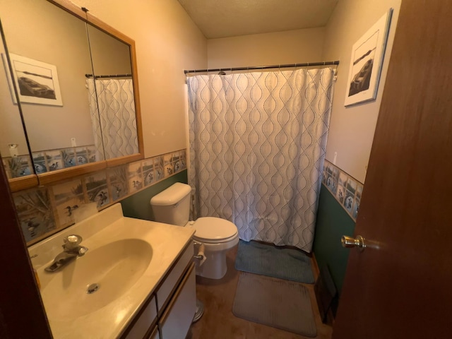 bathroom with curtained shower, vanity, and toilet