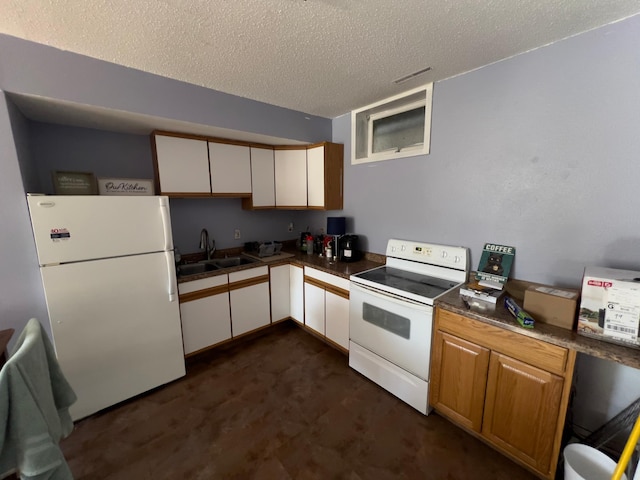 kitchen with white appliances, white cabinets, a sink, and a textured ceiling