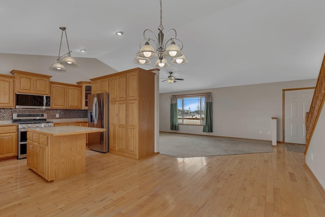 kitchen featuring lofted ceiling, open floor plan, a center island, stainless steel appliances, and light countertops