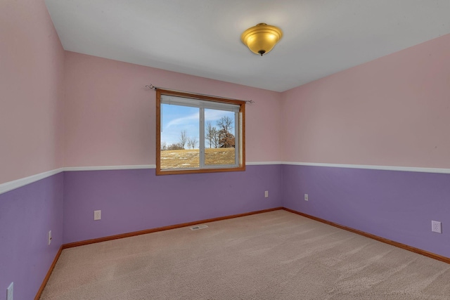 carpeted empty room featuring visible vents and baseboards