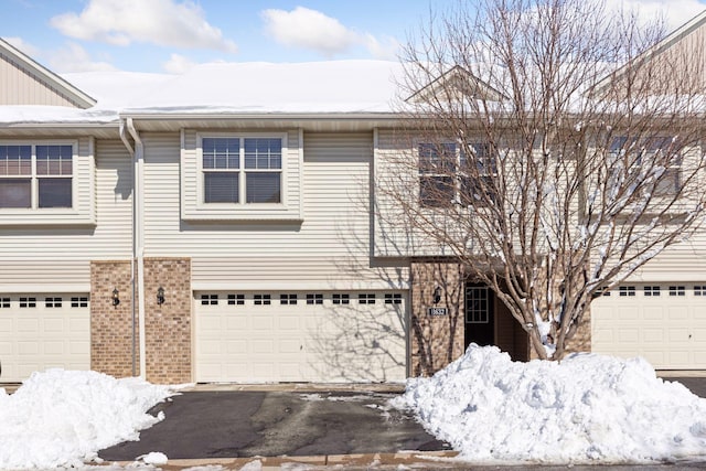 townhome / multi-family property featuring brick siding and an attached garage