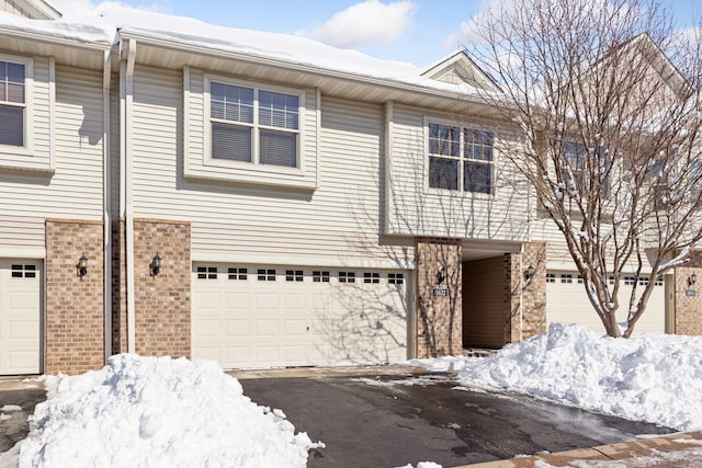 view of property with a garage and brick siding