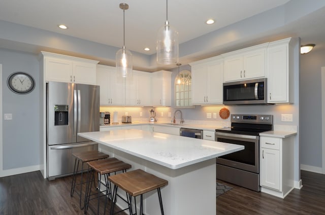 324 Bluebird Dr NW, Isanti, MN 55040 - kitchen with stainless steel appliances, dark wood-style flooring, a kitchen island, white cabinets, and light countertops